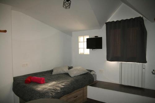 a bedroom with a bed and a tv on the wall at estudio mirador in Güéjar-Sierra