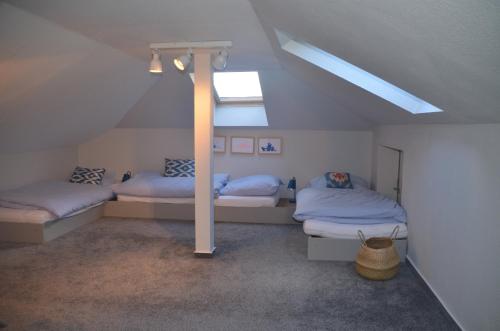 a attic room with two beds and a skylight at Uns Landhus 43 - 5 Personen in Tating