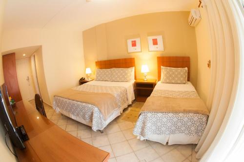 a hotel room with two beds and two lamps at Convair Hotel in Ciudad del Este