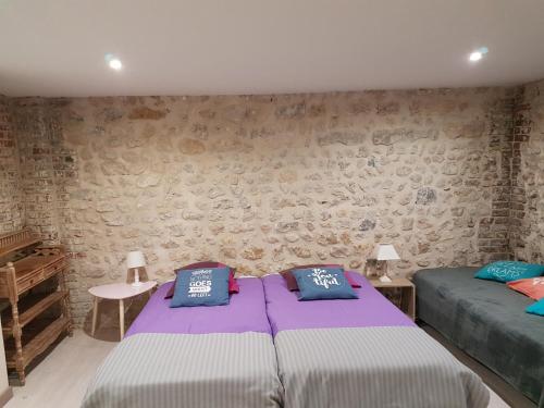 a bedroom with two beds and a stone wall at Home St. Germain in Trouville-sur-Mer