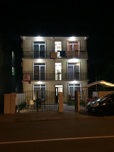 a large white building with a balcony at night at Sofia House in K'obulet'i