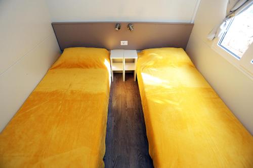 two large beds in a small room with a table at Mobile homes-Slanica in Murter
