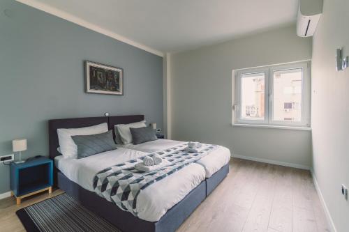 a bedroom with a bed with a black and white blanket at Point Rijeka in Rijeka