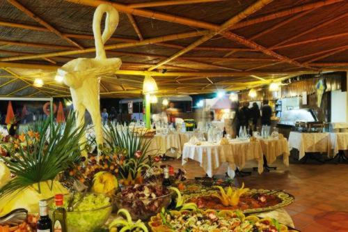 a large room with tables and plates of food at Hotel Oasis in Alghero
