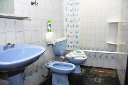 a bathroom with a blue toilet and a sink at Hostal Bernardo Salta in Salta