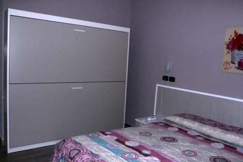 a bedroom with a bed and a dresser next to it at Hotel Astoria in Bordighera