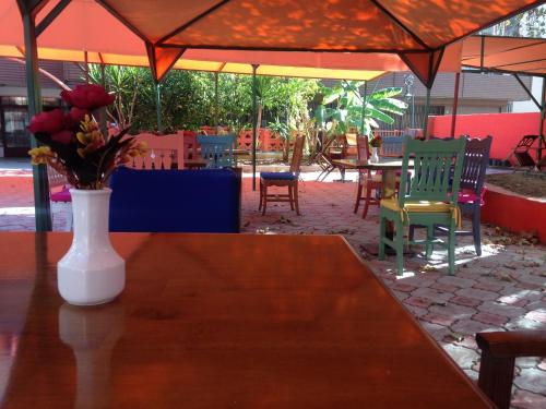 een vaas met bloemen op een tafel met stoelen bij Yalçın Otel in Antalya