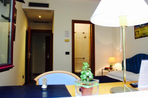 a room with a table with a lamp and a bed at Arcangelo Roof Hotel in Rimini