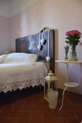 a bedroom with a bed and a table with flowers at Country Hill B&B in Arezzo