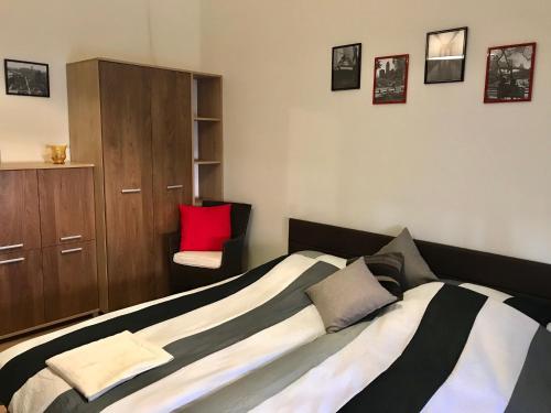 a bedroom with a bed with a red pillow at City Apartman in Pécs