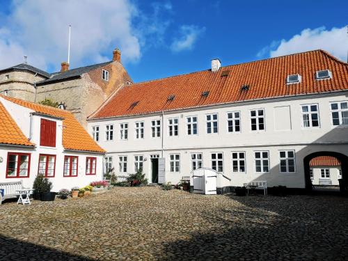 a large white building with an orange roof at Kjobing Manor in Ærøskøbing