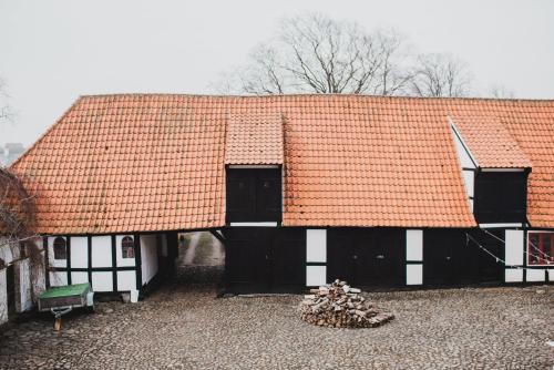 an old building with an orange roof with two windows at Kjobing Manor in Ærøskøbing