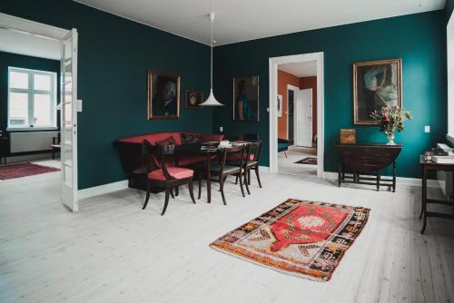 a dining room with green walls and a table and chairs at Kjobing Manor in Ærøskøbing