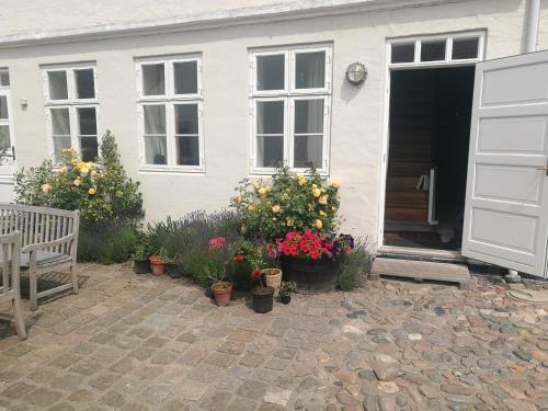 a white house with flowers in front of it at Kjobing Manor in Ærøskøbing