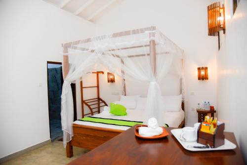 1 dormitorio con 1 cama con mesa de madera en Odailem Resort - Talpe en Galle