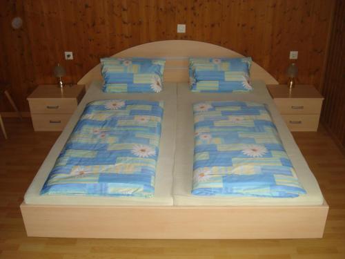 a large wooden bed with four pillows on it at Haus Mondspitze in Bürserberg