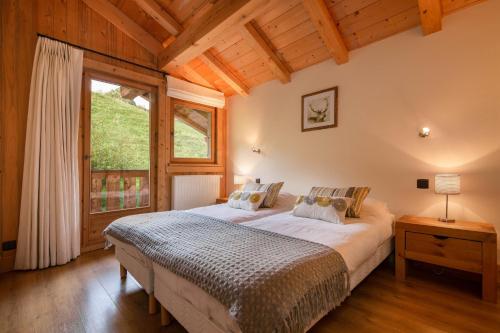 ein Schlafzimmer mit einem großen Bett und einem Fenster in der Unterkunft Chalet Anelie Happy Rentals in Les Houches