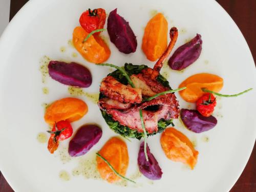 a plate of food with meat and vegetables on it at Golden Tulip Porto Gaia in Vila Nova de Gaia