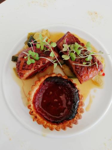 a white plate of food with meat and sauce at Golden Tulip Porto Gaia in Vila Nova de Gaia