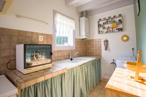 - une cuisine avec une cheminée et un évier dans l'établissement Maison Lous Amics, à Orx