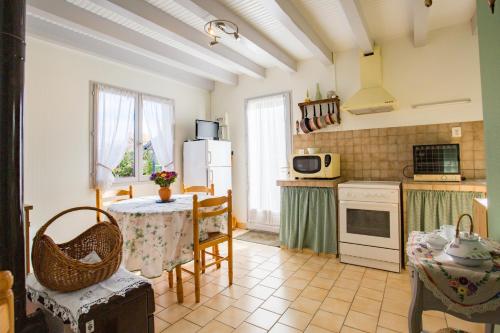 une cuisine avec une table, des chaises et un réfrigérateur dans l'établissement Maison Lous Amics, à Orx