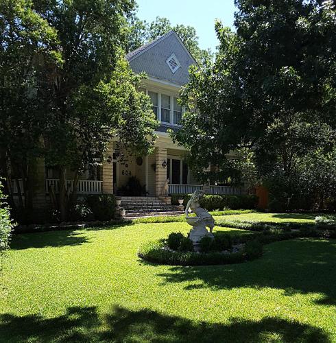 a house with a statue of a bear in the yard at Strickland Arms Bed and Breakfast in Austin