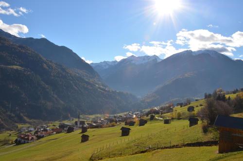 a village in a field with mountains in the background at Neuner Charlotte Preise inclusive Sommercard in Wenns