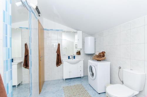 a bathroom with a toilet and a washing machine at Dalmatian village charm - spacious villa with pool near Trogir in Primorski Dolac