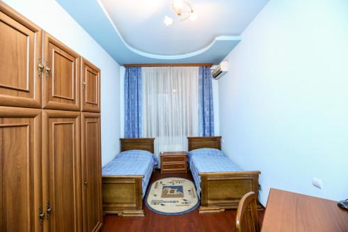 Habitación pequeña con 2 camas y mesa. en Apartment #1 in the city center, en Ereván