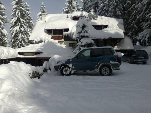 a truck covered in snow in front of a house at Vila Jelena Zlatar Nova varoš in Brdo
