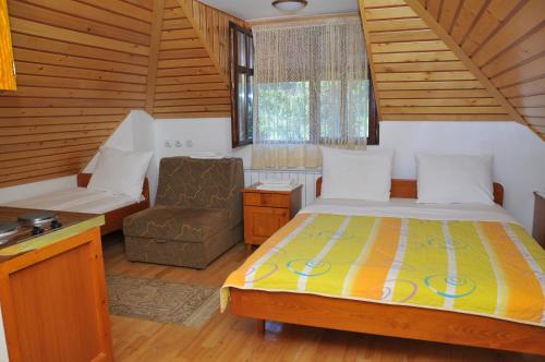 a small bedroom with a bed and a chair at Vila Jelena Zlatar Nova varoš in Brdo