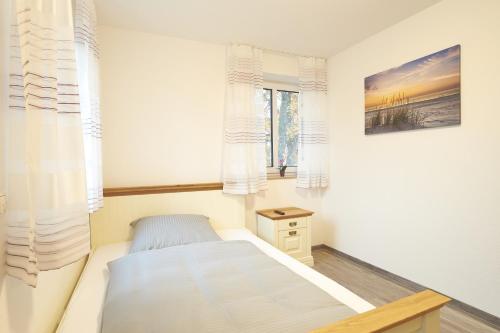a small bedroom with a bed and windows at Zur Friedenseiche in Aichach