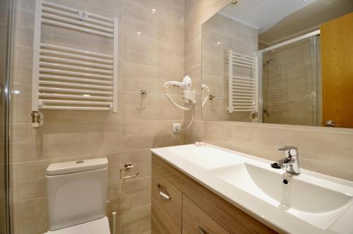 a bathroom with a sink and a toilet and a mirror at Apartment Bonsol in Lloret de Mar