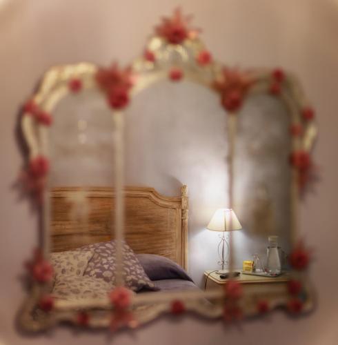 a bedroom with a bed with a mirror on the wall at de' Montetini in Arezzo