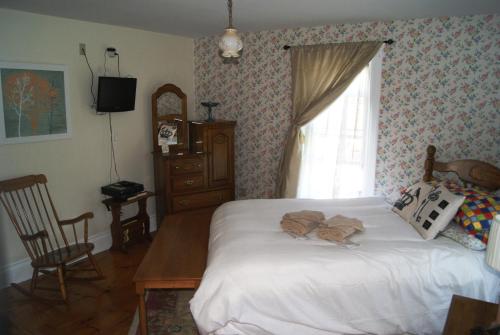 a bedroom with a white bed and a window at Ye Olde Walkerville Bed & Breakfast in Windsor