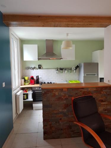 une cuisine avec un comptoir et une chaise dans l'établissement maison à 300 mètres de la mer, à Yport