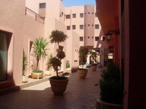 um pátio com vasos de plantas na frente de um edifício em LINA APPARTEMENT em Marrakech