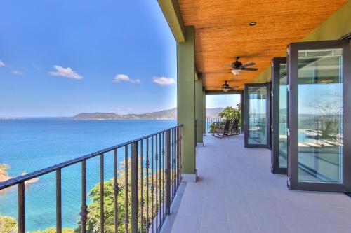 a house with a balcony with a view of the ocean at 360 Splendor Del Pacifico Residences in Playa Flamingo