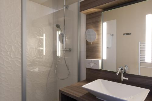 a bathroom with a sink and a shower at Clos St Eloi, The Originals Relais in Thiers