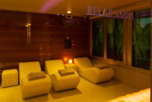a living room with two yellow chairs and a sign at Hotel Ascot & Spa in Rimini