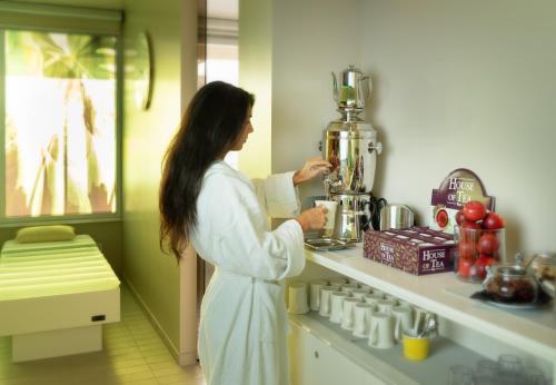 a woman standing in a kitchen with a blender at Hotel Ascot & Spa in Rimini