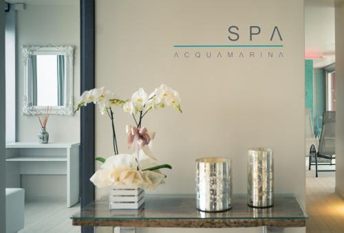 a table with a vase of flowers on it at Hotel Ascot & Spa in Rimini