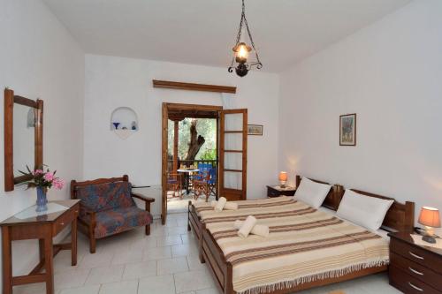a bedroom with a large bed and a chair at House Katia in Kalamos