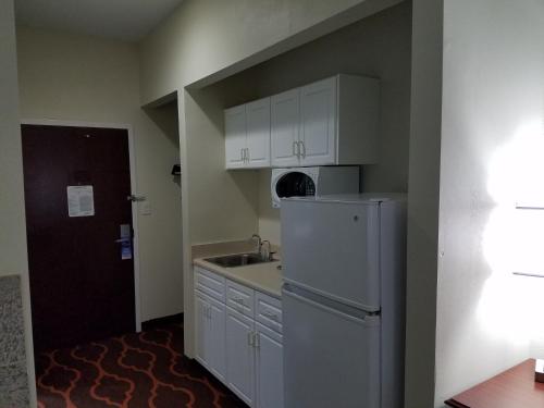 a kitchen with a white refrigerator and a sink at Baymont by Wyndham Grovetown Augusta in Augusta
