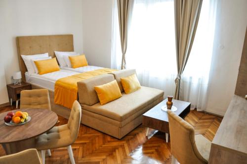 a bedroom with a bed and a table and a couch at MAROON Free Parking in Sarajevo