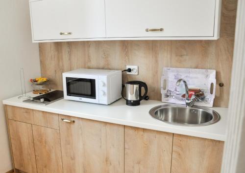 a kitchen counter with a sink and a microwave at MAROON Free Parking in Sarajevo