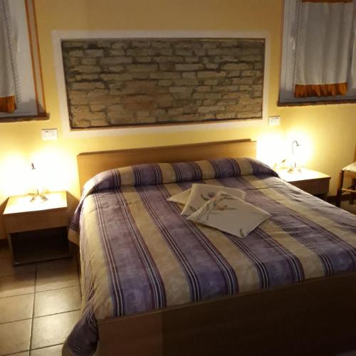 a bedroom with a bed with two night stands and lamps at Agriturismo Trava in Portoverrara