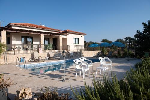 una casa con piscina con sedie e ombrelloni di Adonis Villa a Coral Bay
