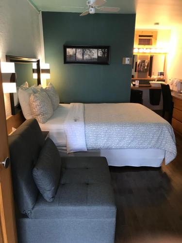 a bedroom with a large bed and a couch at Auberge Hotel Spa Watel in Sainte-Agathe-des-Monts