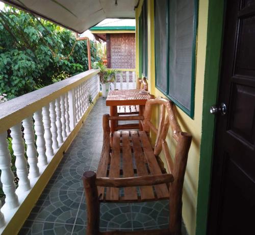 a porch with a wooden bench on a balcony at Guanna's Place Room and Resto Bar in Malapascua Island